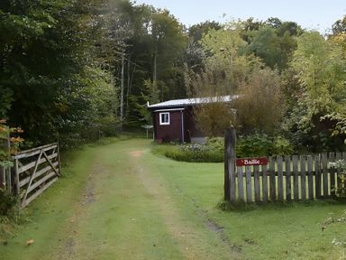 A path leading to a shed with a sign at Baillie Chalet