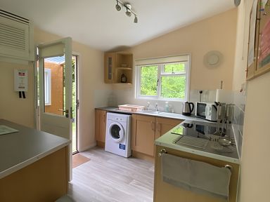 A kitchen with a washing machine and appliances at Baillie Chalet