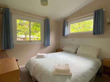 A bedroom with a bed and windows at Baillie Chalet