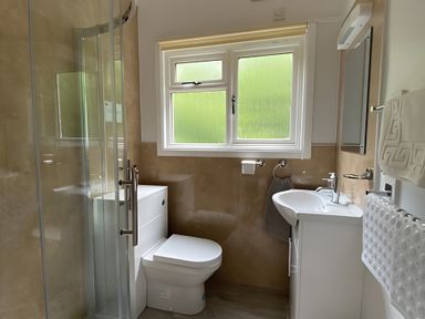 A bathroom with a shower toilet and sink at Baillie Chalet 