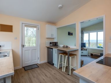 A kitchen with a door and appliances at Kilninver Chalet