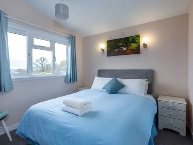 A bedroom with a bed and bedside table at Kilninver Chalet