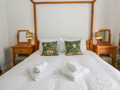 A bedroom with a bed and bedside tables at Capel Llani in Llanidloes