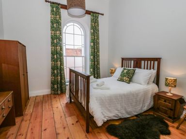 A bedroom with a bed and wardrobe at Capel Llani in Llanidloes
