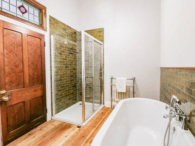 A bathroom with a shower and bathtub at Capel Llani in Llanidloes