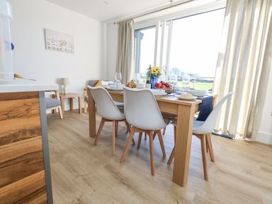A dining room with a table and chairs at Sea Fern House - 36 Poole