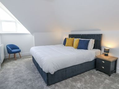 A bedroom with a bed and nightstand at Sea Fern House - 36 in Poole