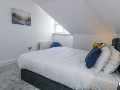 A bedroom with a bed and painting at Sea Fern House - 36 Poole