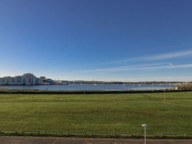A view of water with boats and grass at Sea Fern House - 36 Poole