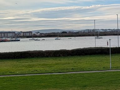 View of water with boats and green grass at Sea Fern House - 36 Poole