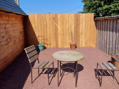 An outdoor seating area with a wooden table and chairs at location