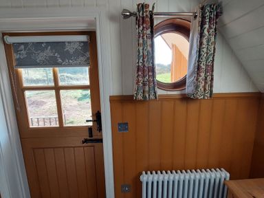 An entryway with a door and a round window at The Cottage in the Countryside
