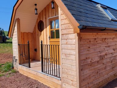 A cabin exterior with wood siding and a railing at 