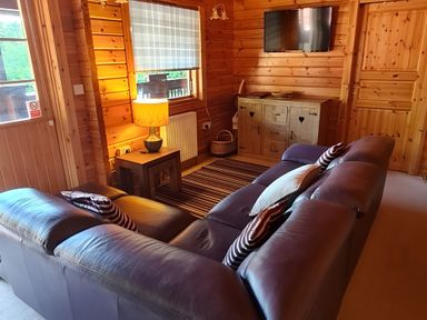 A living room with a sofa and lamp at Gisburn Forest Lodge