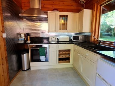 A kitchen with appliances and countertops at Gisburn Forest Lodge