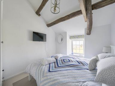 A bedroom with a bed and television at Bwthyn Nain in Harlech