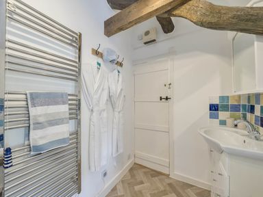 A bathroom with a towel rail and sink at Bwthyn Nain in Harlech