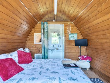A bedroom with a bed and television at St Austell Glamping in St Austell