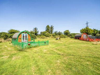 An outdoor area with green and red cabins at St Austell Glamping in St Austell