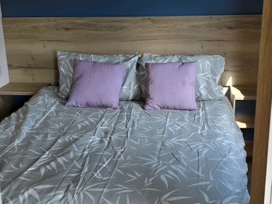 A bed with pillows and sheets at Caravan
