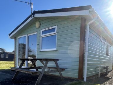 A cabin with a table and bench outside at Embury