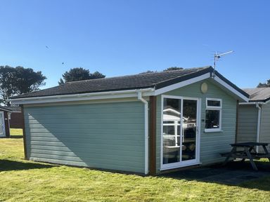 A cabin with a table and seats outside at Embury 