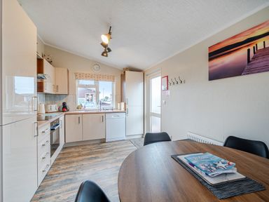 A kitchen with cabinets and a dining table at 311 Bridlington