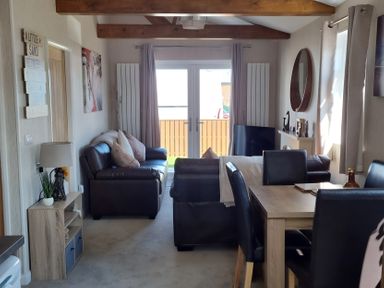 A living room with sofa and dining area at 50 Bridlington