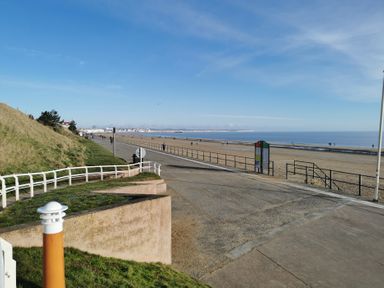 A beach with a walkway and a sign at 50 Bridlington