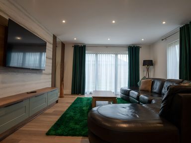 A living room with a sofa, coffee table, and television at The Galloway in Morpeth