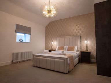 A bedroom with a bed and bedside table at The Galloway in Morpeth