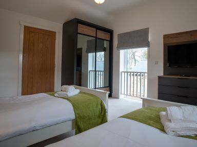 A bedroom with two beds and a wardrobe at The Galloway in Morpeth