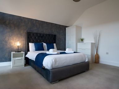 A bedroom with a bed and bedside table at The Galloway in Morpeth