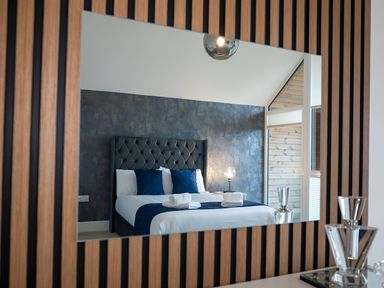 A bedroom featuring a bed with blue pillows and towels at The Galloway in Morpeth