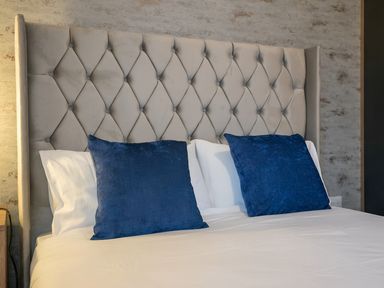 A bedroom with a bed and blue pillows at The Shearling in Morpeth