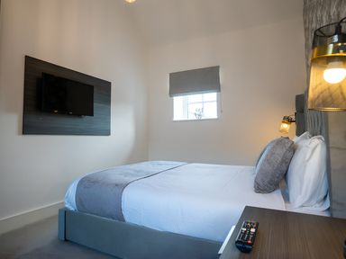 A bedroom with a bed and a television at The Shearling in Morpeth