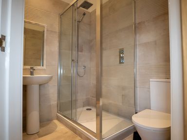 A bathroom with a shower, sink, and toilet at The Shearling in Morpeth