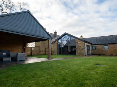 A house with grass and furniture in the yard at The Shearling in Morpeth