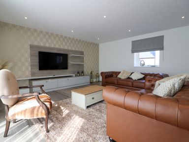 A living room with a television and couch at The Newland in Morpeth