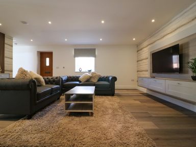 A living room with a sofa and television at The Newland in Morpeth