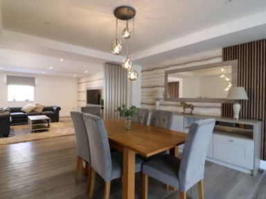 A dining room with a wooden table and grey chairs at The Newland in Morpeth