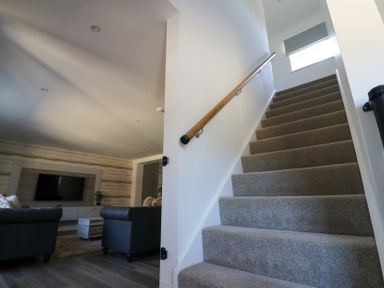 A staircase leading to an upper level with a living room in view at The Newland in Morpeth