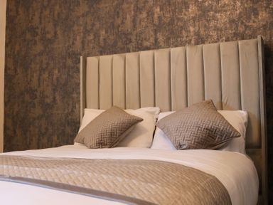 A bedroom with a bed and decorative pillows at The Newland in Morpeth