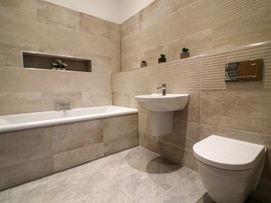 A bathroom with a bathtub, sink, and toilet at The Newland in Morpeth