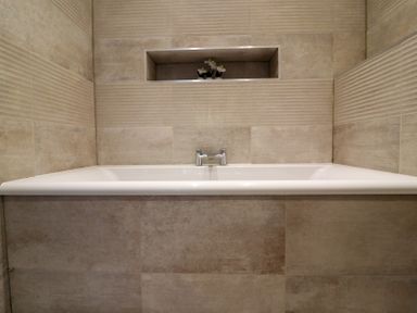A bathtub with faucet and decorative plant in a bathroom at The Newland in Morpeth