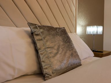 A bedroom with a pillow and lamp on a nightstand at The Newland in Morpeth