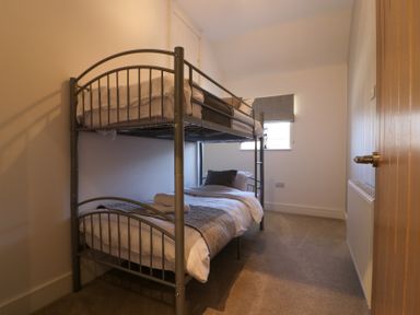 A bunk bed with linens and a cushion at The Newland in Morpeth