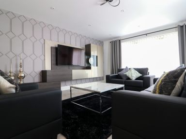 A living room with a television and coffee table at The Gavel in Morpeth