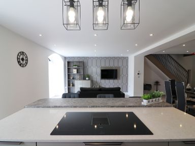 A kitchen with a cooktop and a sofa in the background at The Gavel in Morpeth