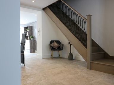 A hallway with a staircase and a chair at The Gavel in Morpeth